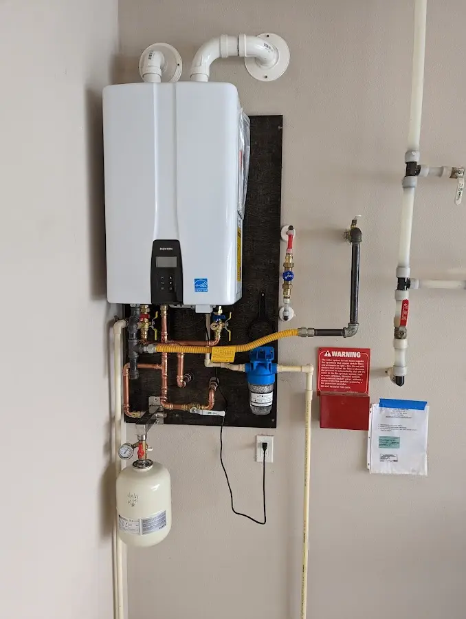 Professional plumber installing copper piping in a Hopedale home